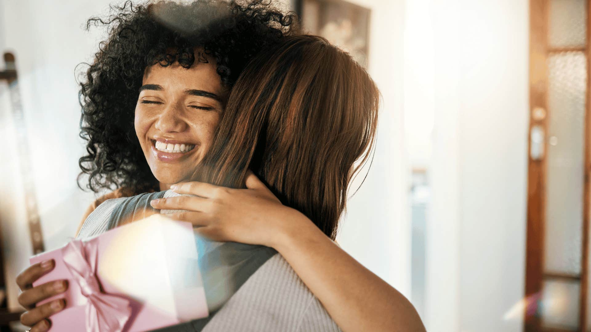 woman hugging friend while receiving gift
