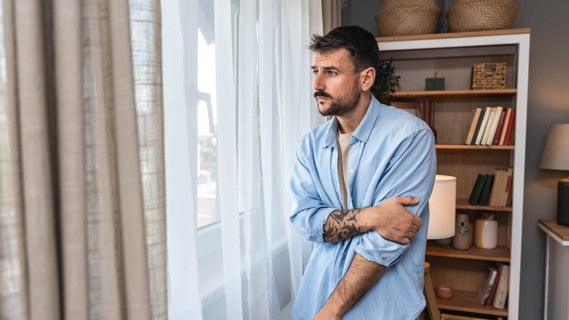 tired man looking out window 