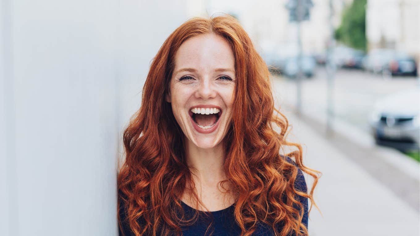 Vibrant laughing redhead woman after first date 