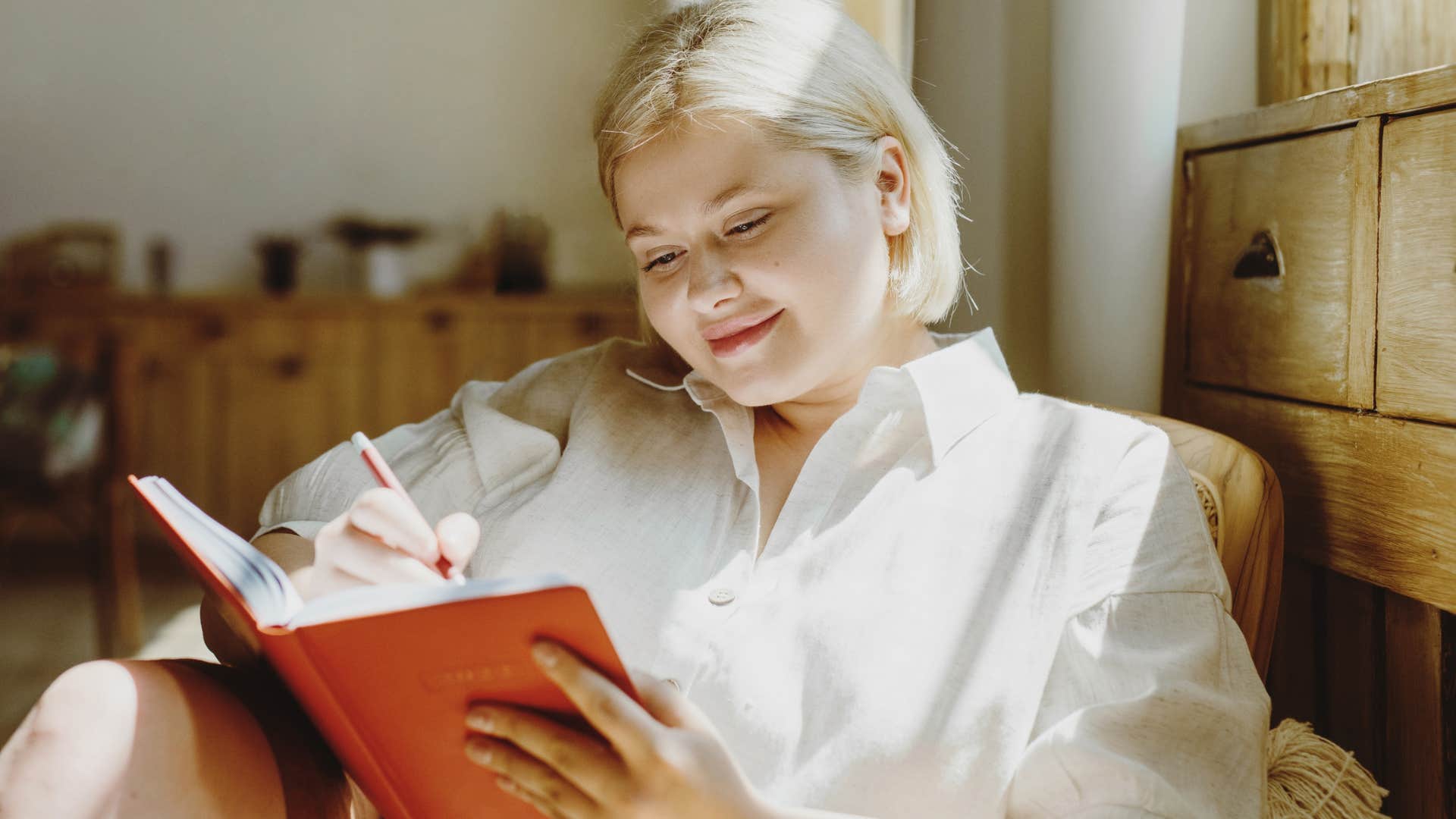 creative woman smiling and writing in her journal