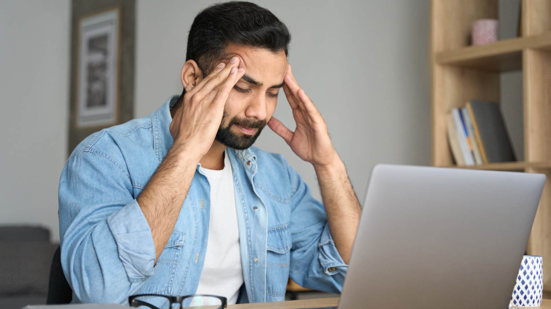 stressed man holding his temples