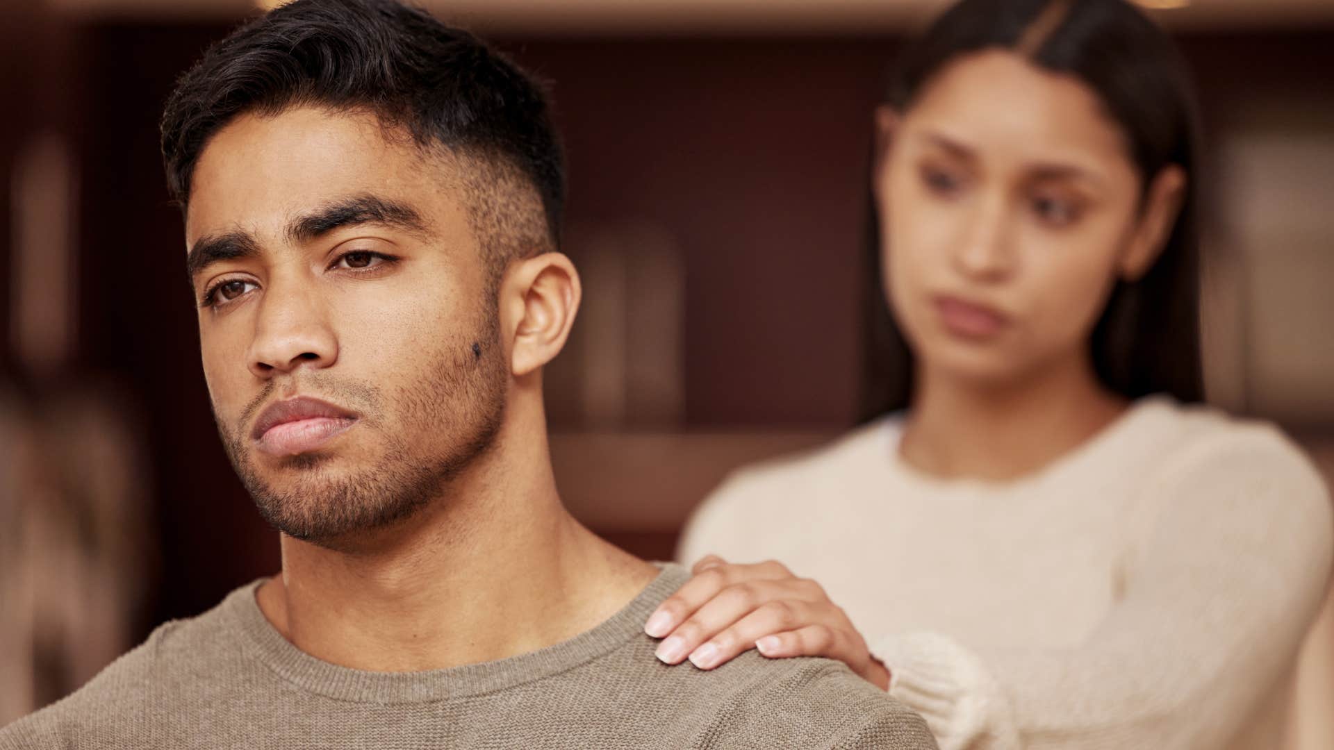 upset man turned away from concerned wife