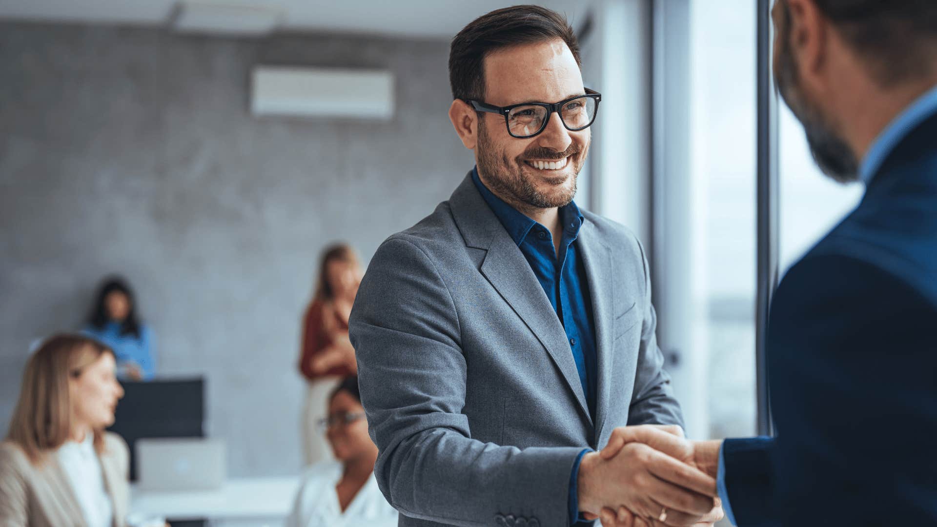 man confidently shaking employer's hand