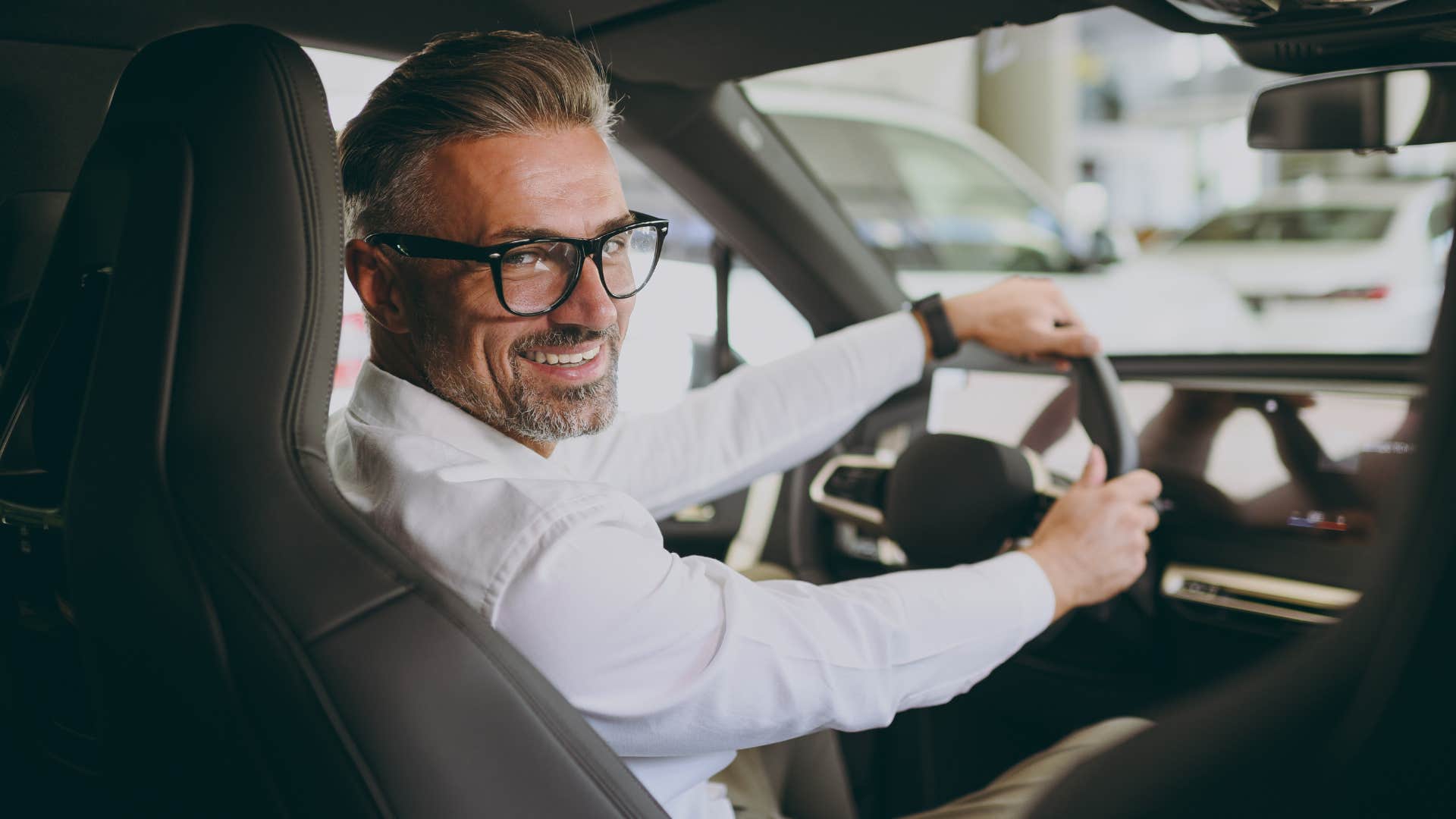 Professional man smiling while commuting to work in his car