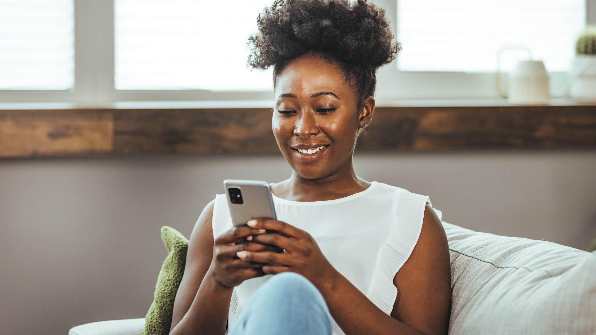 Young woman smiling and posting a photo without a face-changing filter on her phone