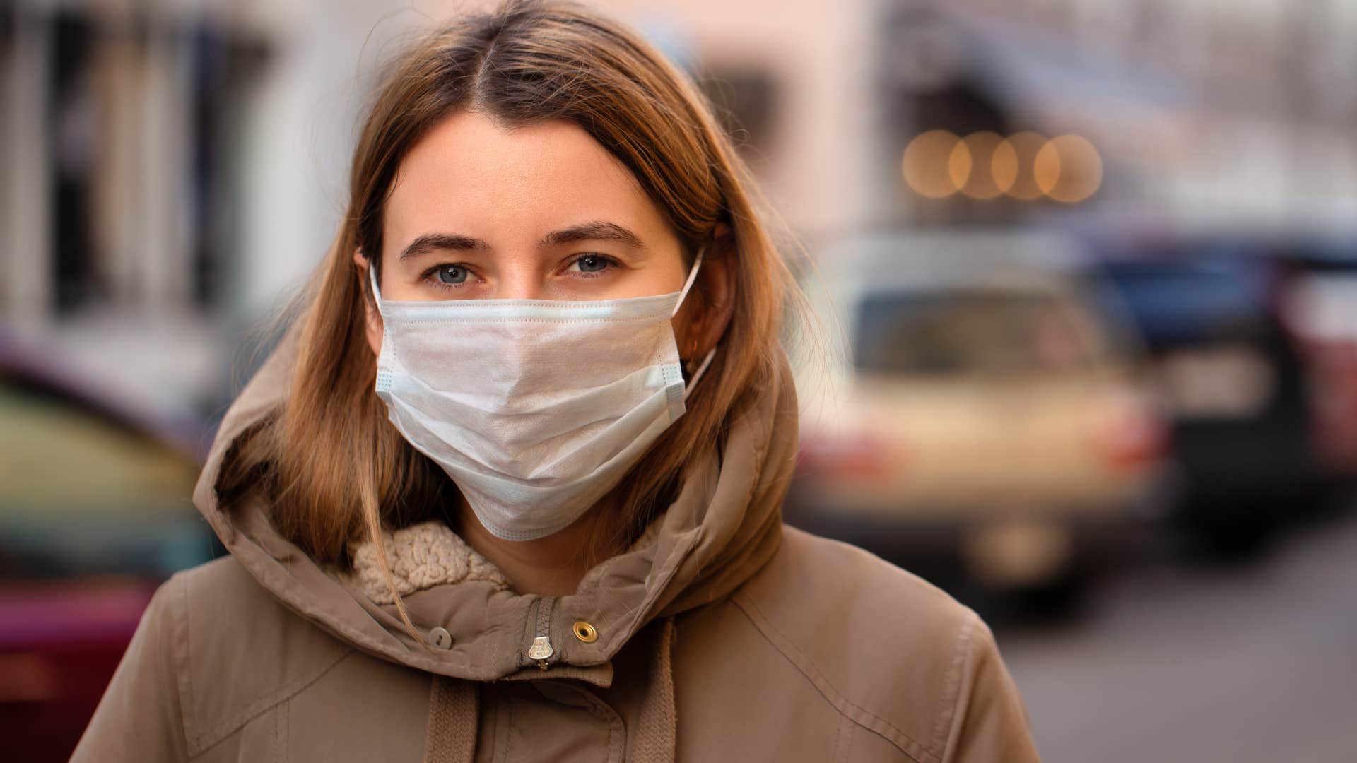 Woman looking at the camera wearing a face mask daily