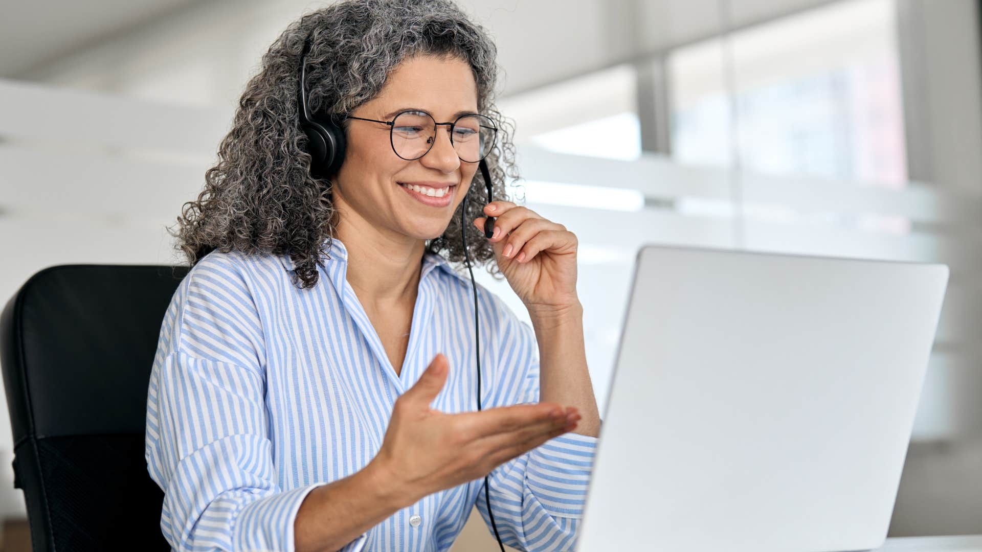 Professional woman smiling and scheduling video calls with friends on her laptop