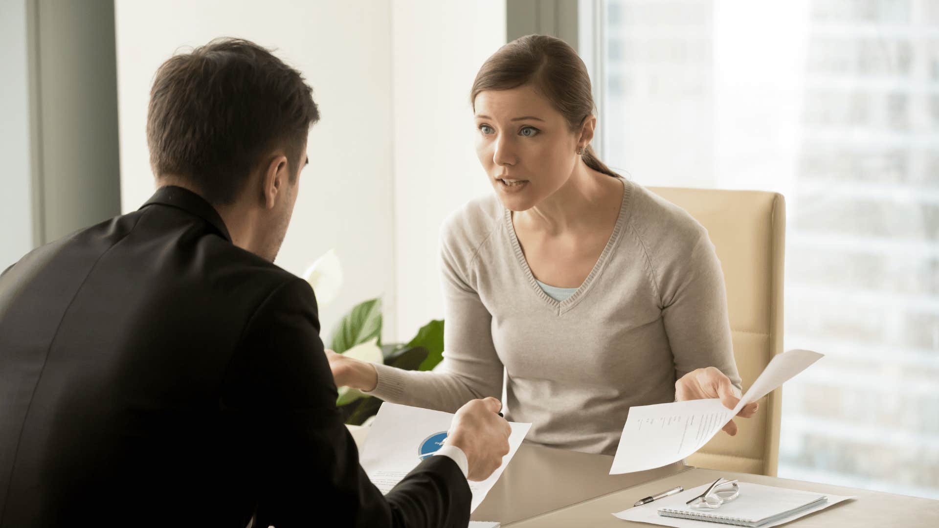 woman arguing with man at desk