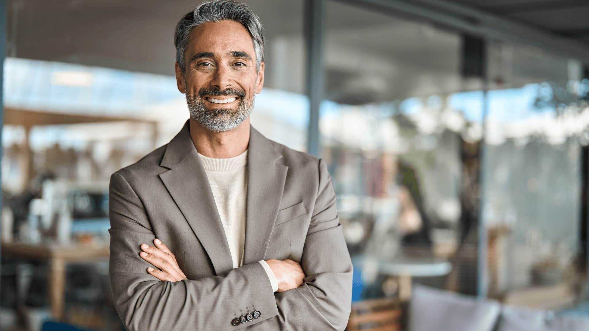 smiling emotionally normal man with his arms crossed
