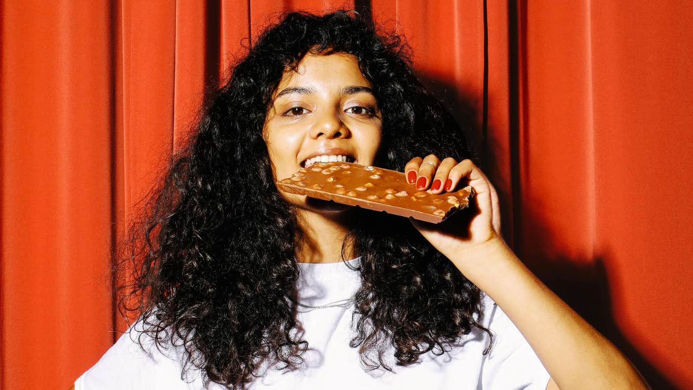 The Guilty Pleasure The Smartest People Always Have, According To Research Smart person giving into guilty pleasure.