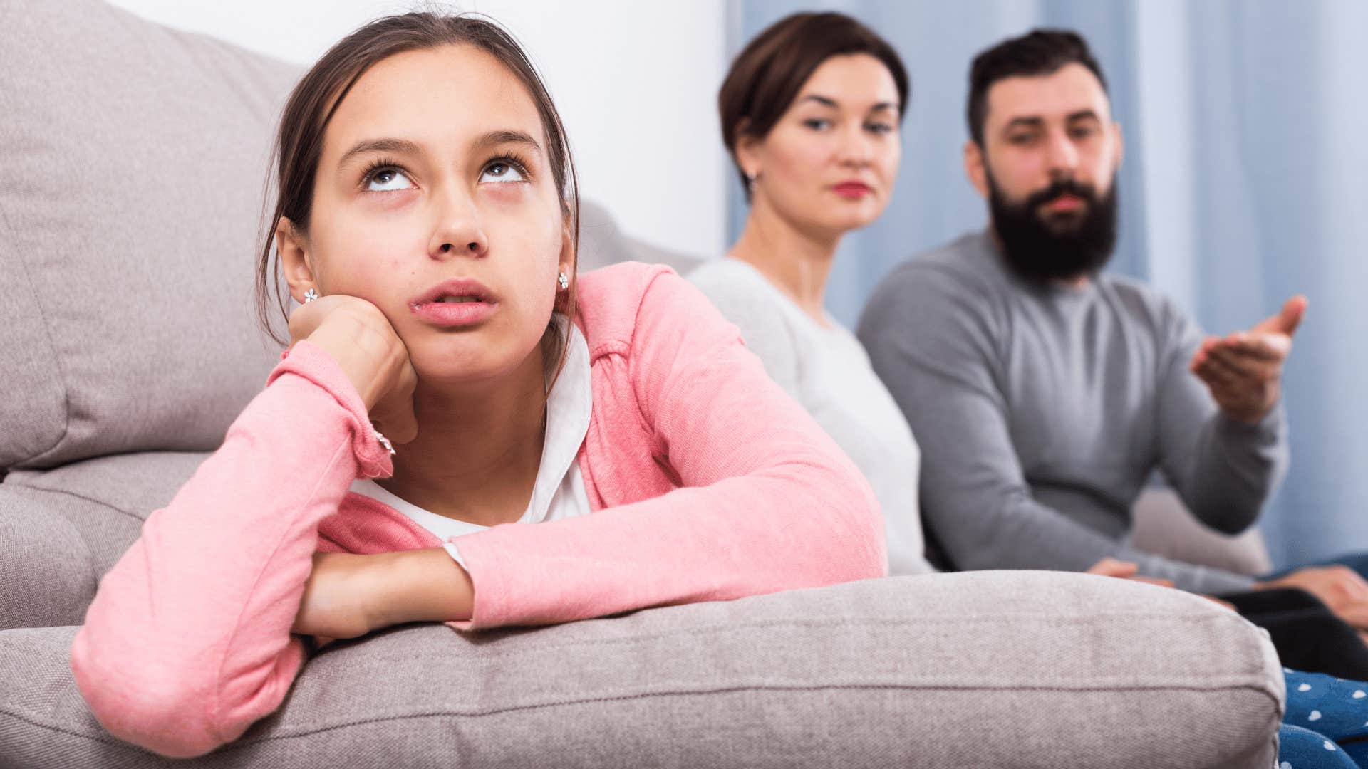 parents with upset daughter on couch