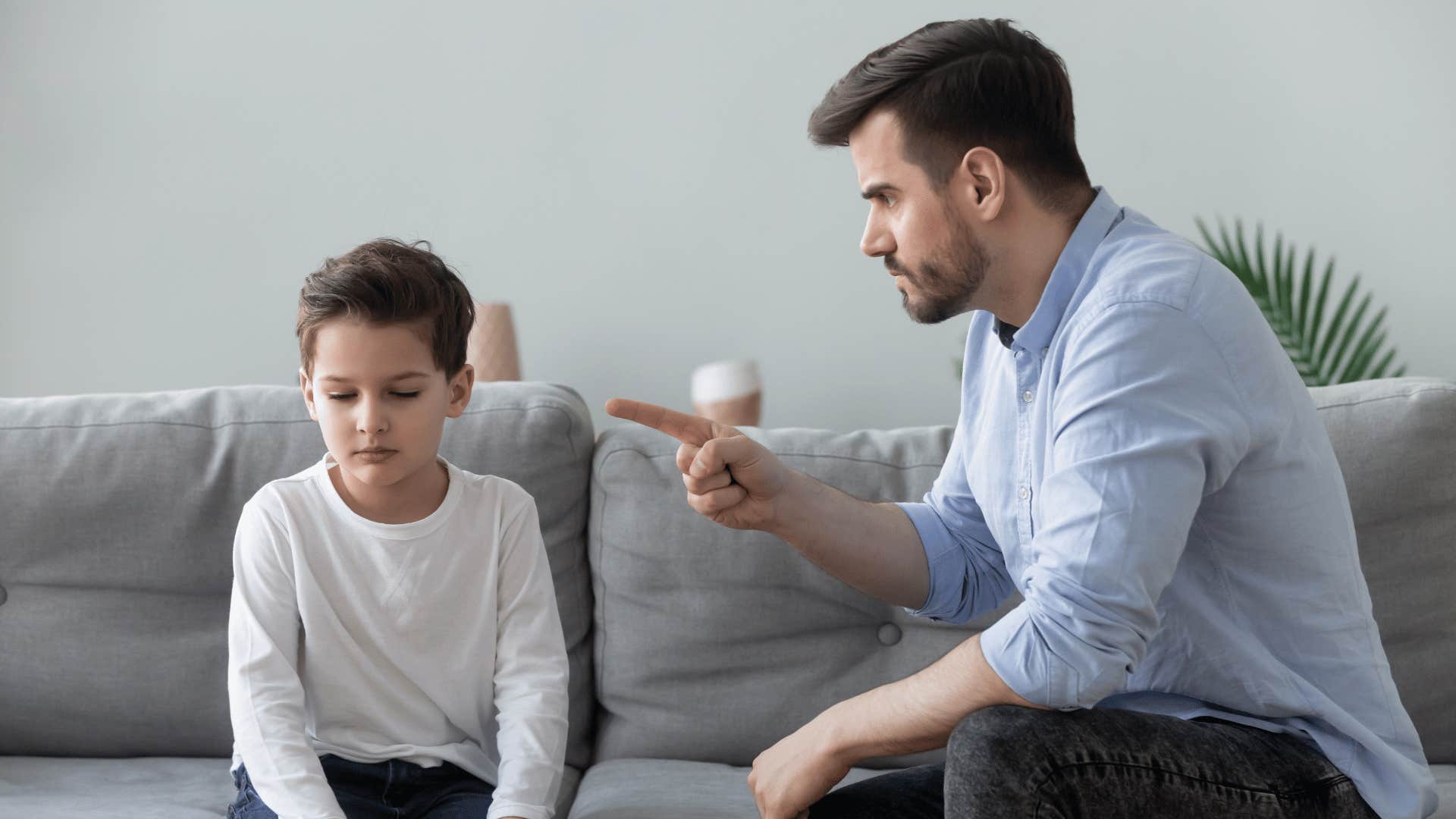 father yelling at son on couch
