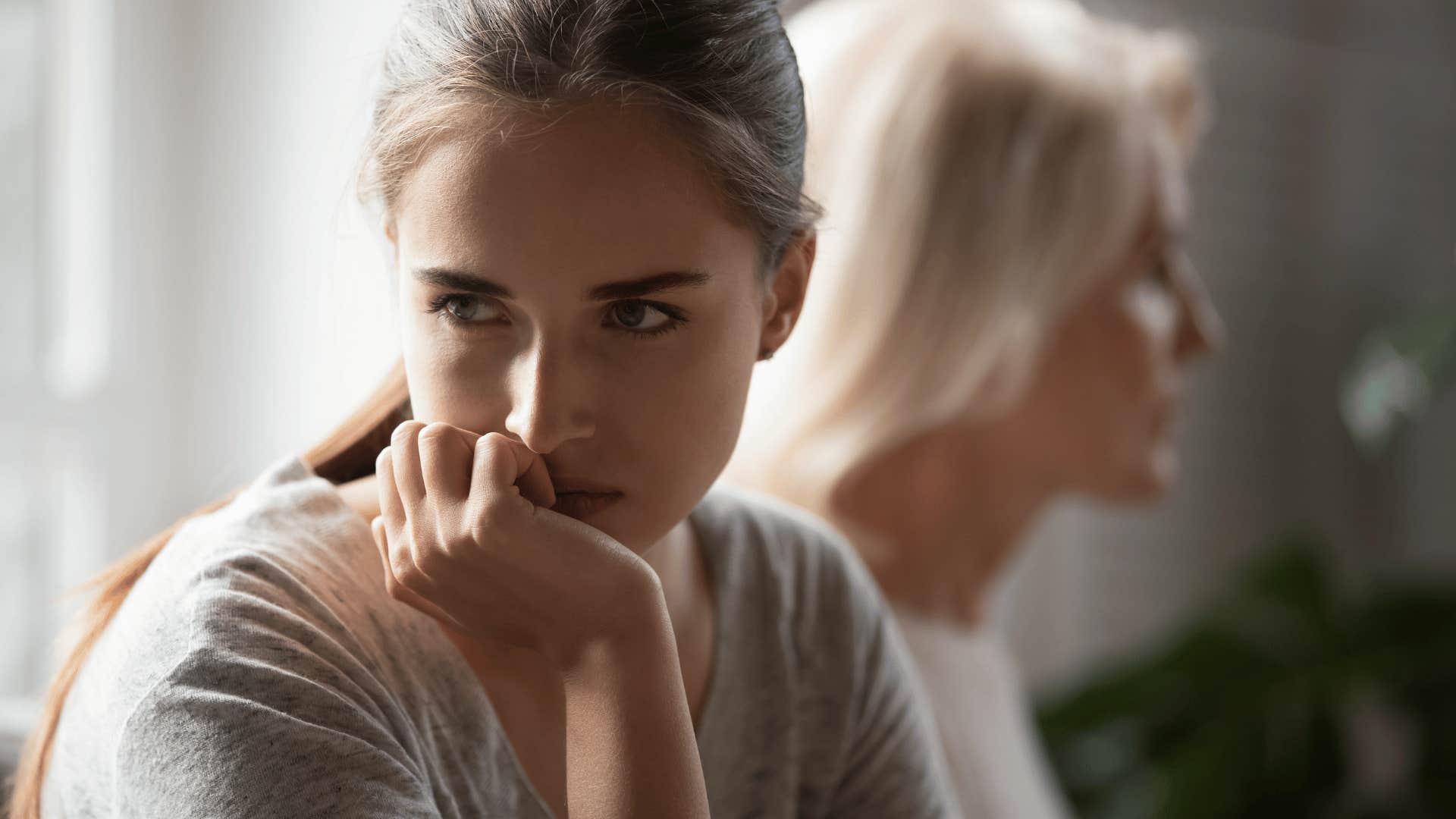 upset woman sitting next to mother