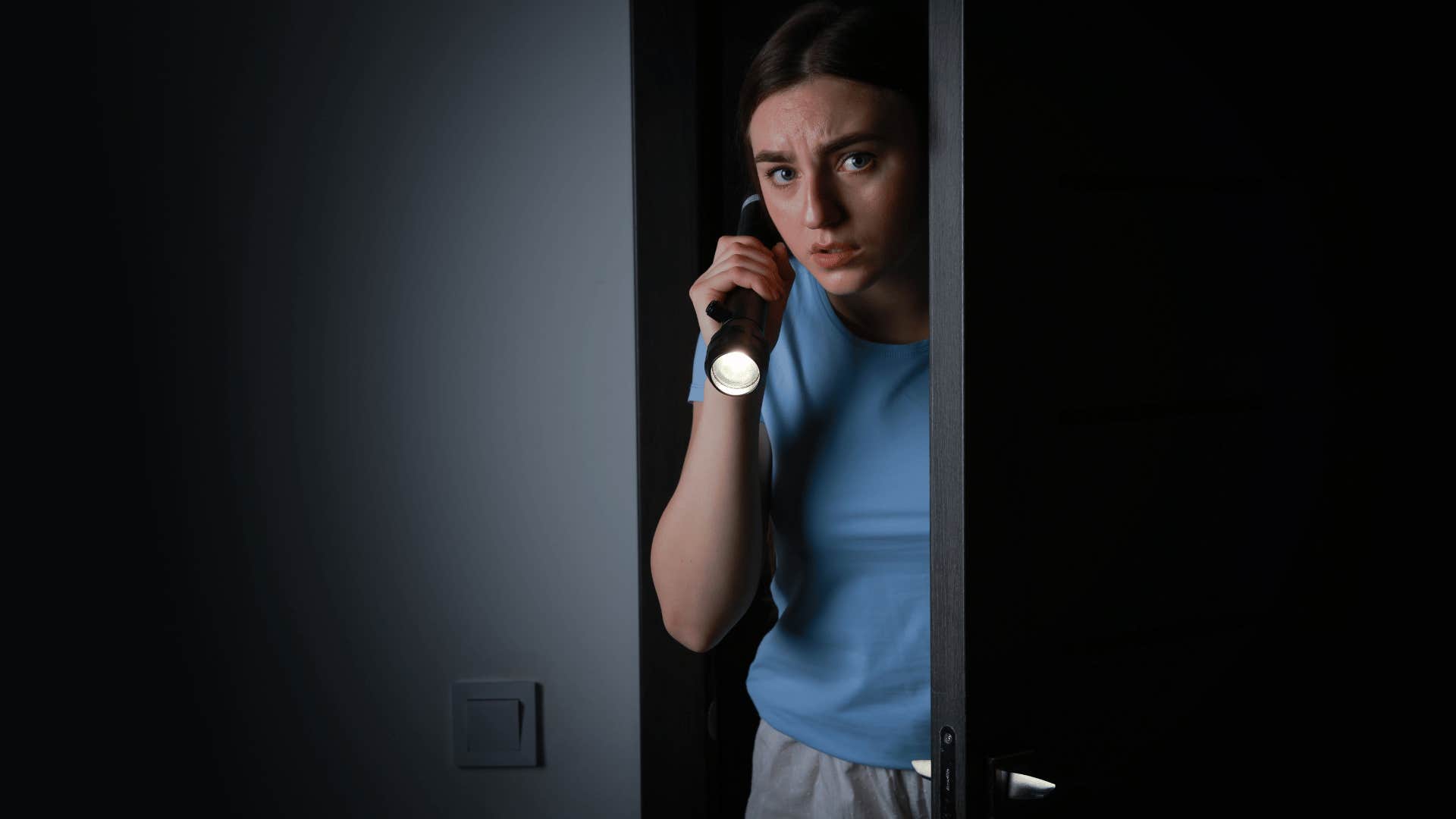 woman in a horror movie using a flashlight