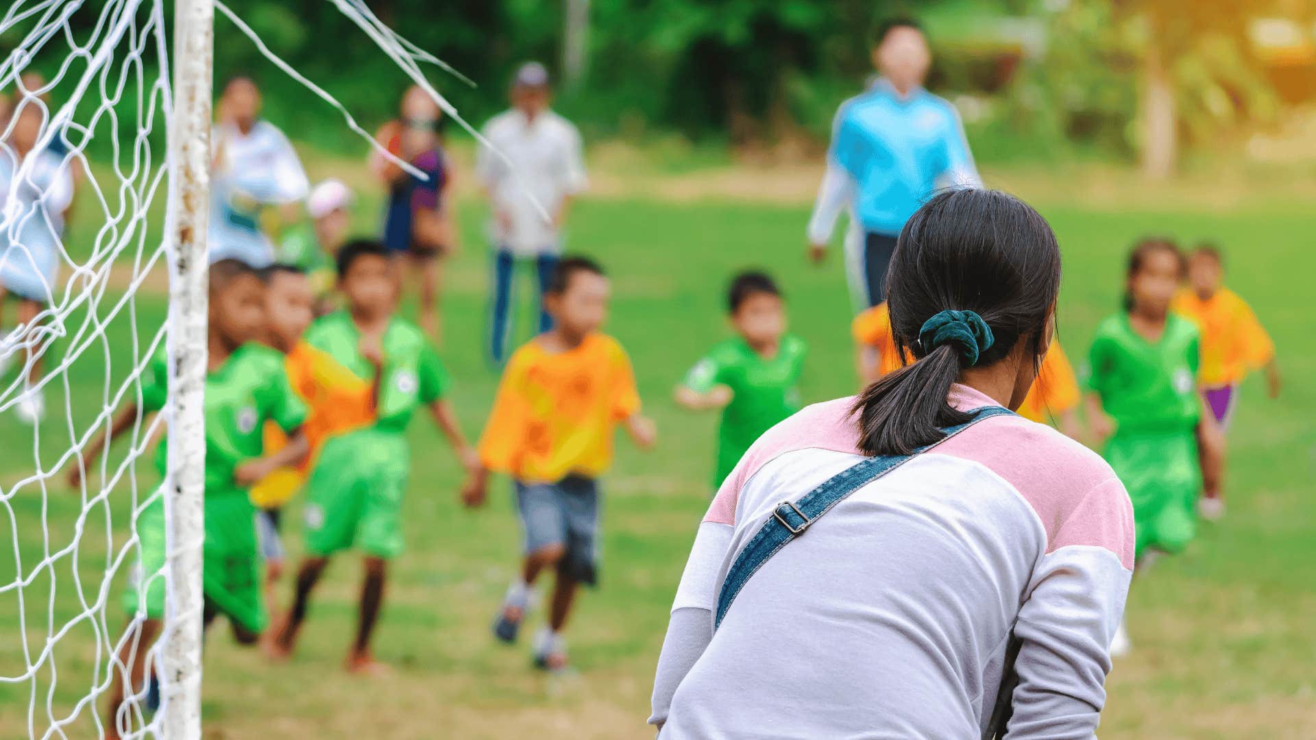 woman watching kids play sports as incredible side effect of being a parent