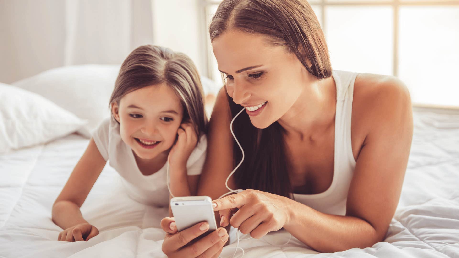 woman listening to music with daughter as incredible side effect of being a parent