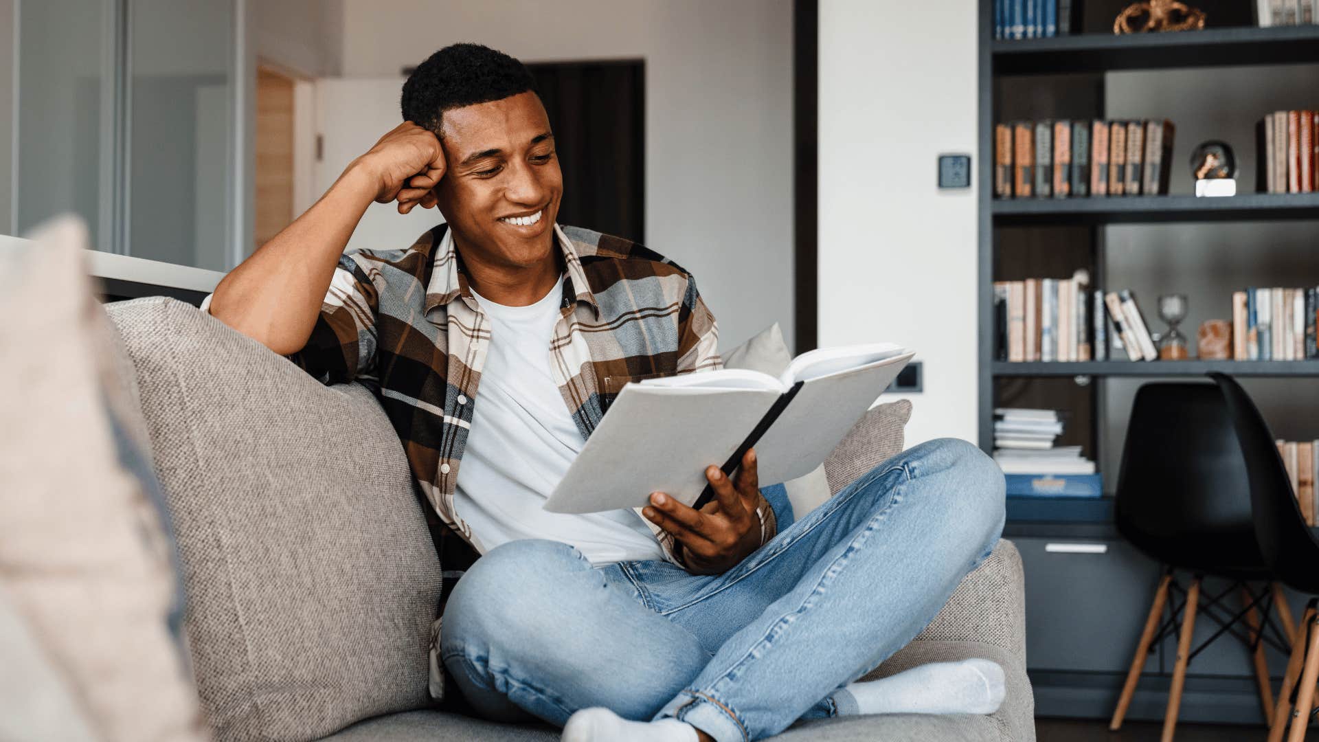 happy man reading a book on the couch