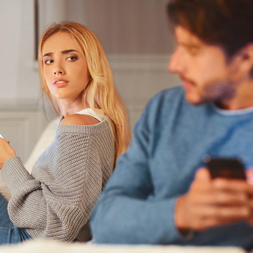 upset man next to woman on phone who is pushing him away