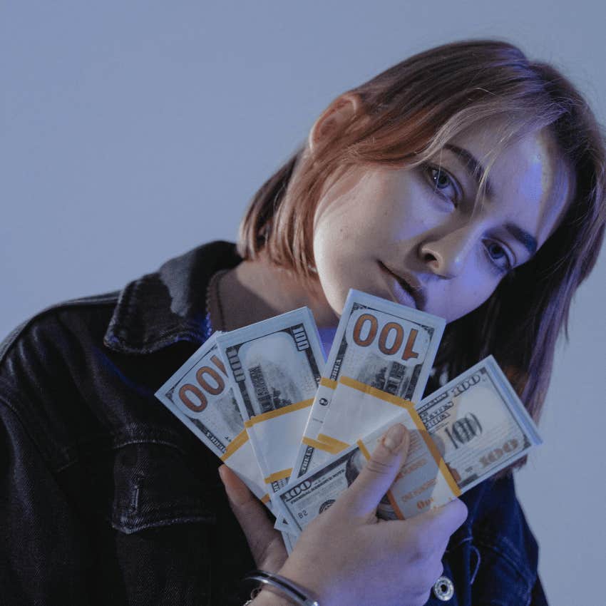 woman holding money after being taught timeless lessons