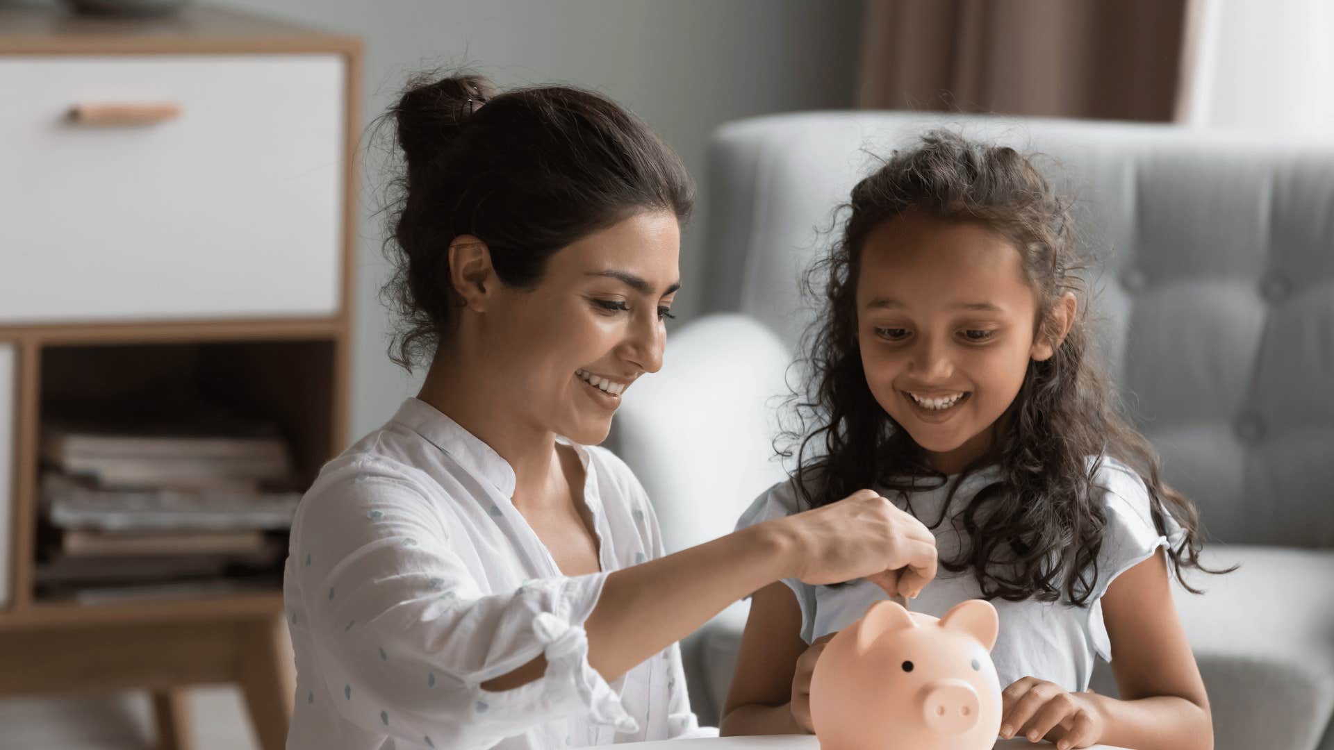 mother and daughter with piggy bank