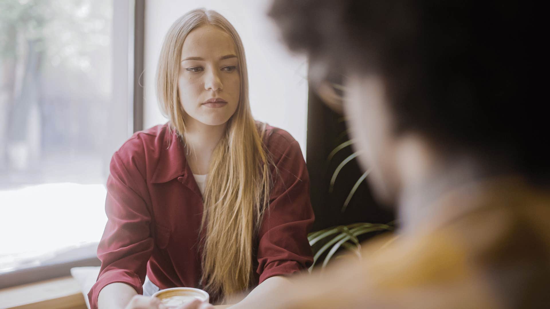 serious woman looking untrusting of friend