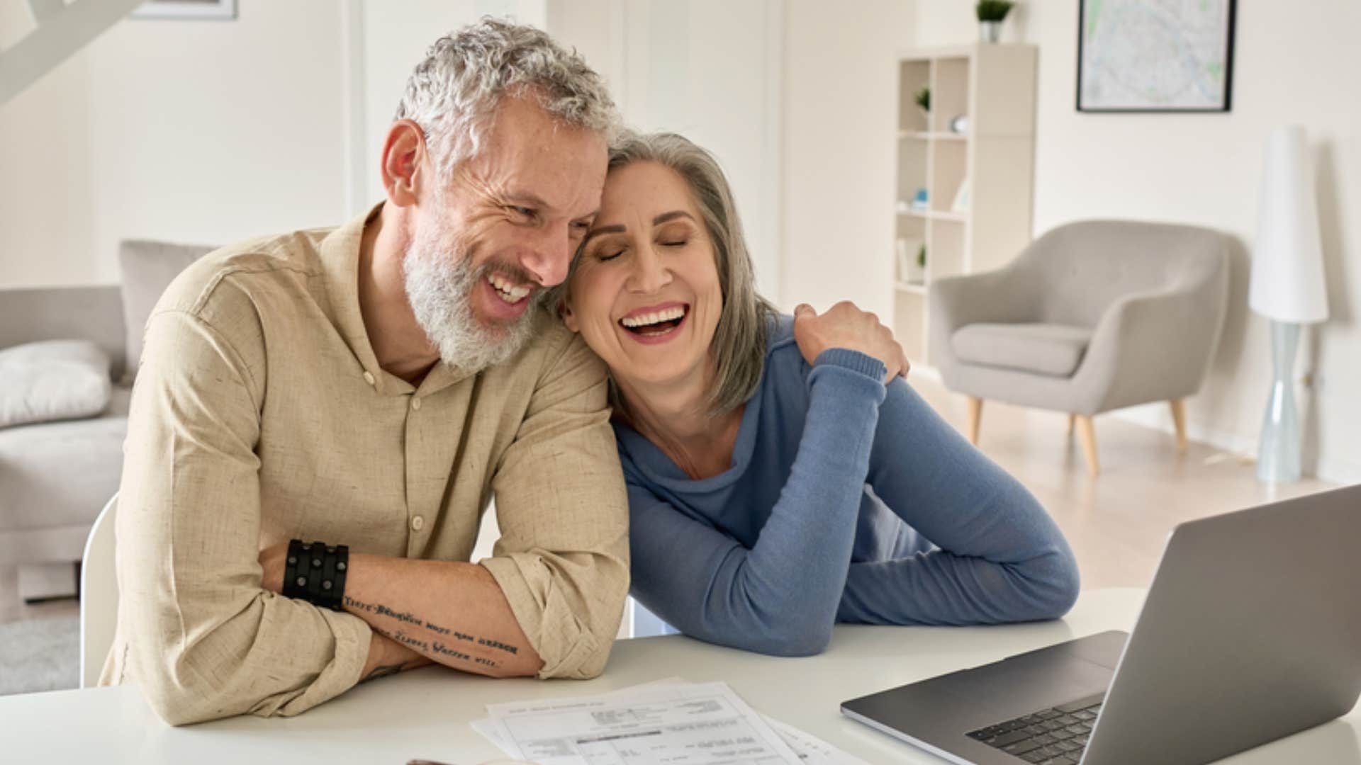 smiling couple watching a laptop together