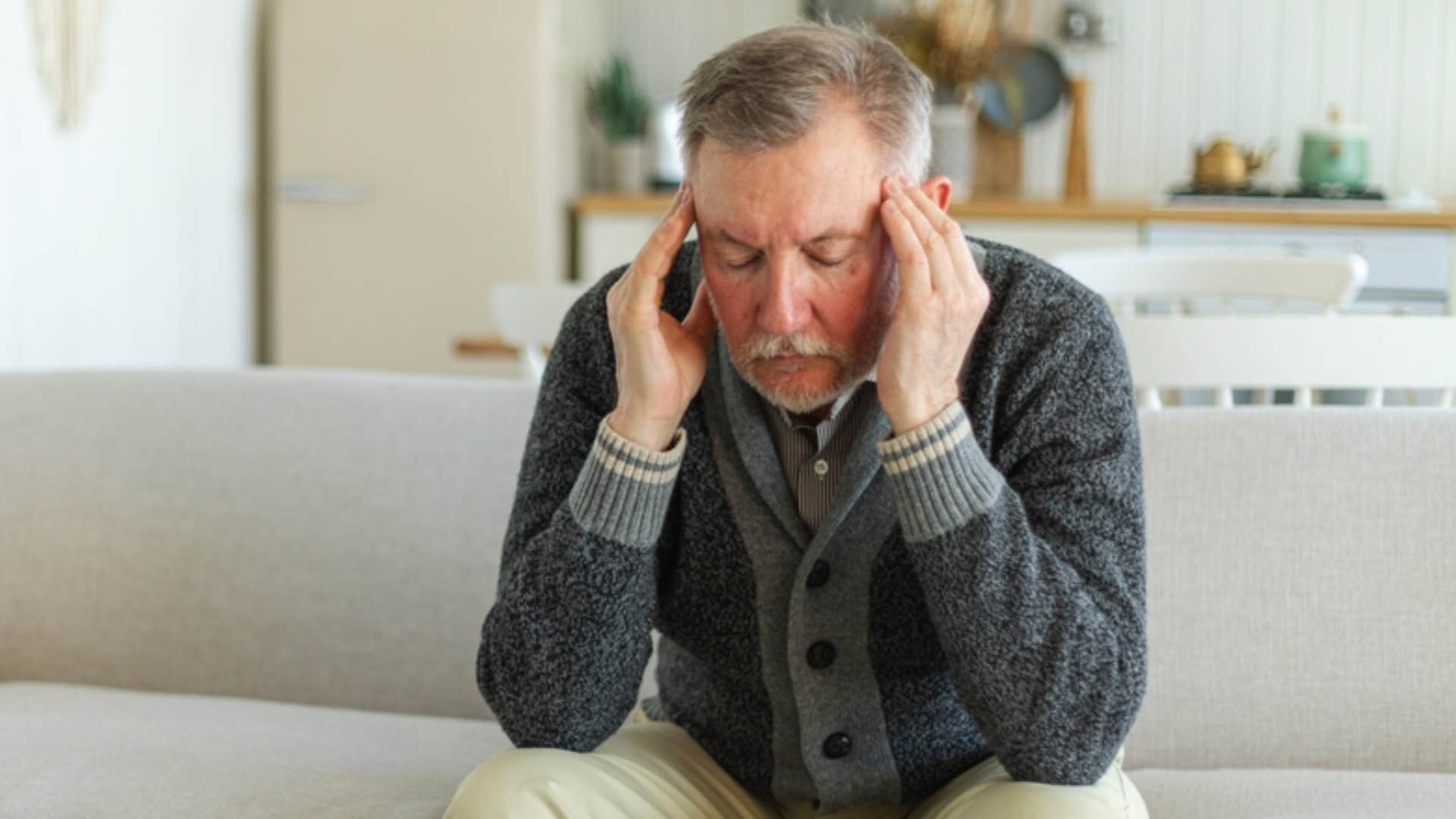 stressed man rubbing his temples