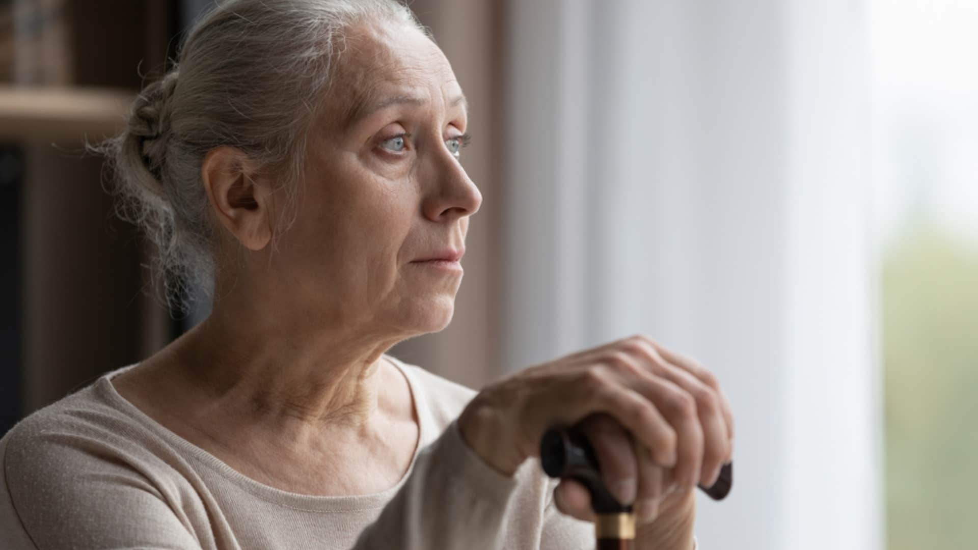 older woman holding onto cane