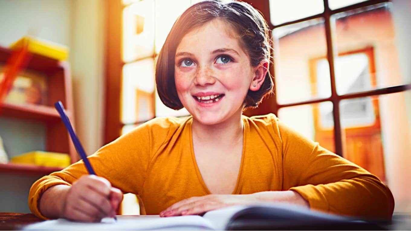 Sacrifices Made By Parents Want Best For Kids Grade school aged girl writing in notebook, happy because her parents made personal sacrifices
