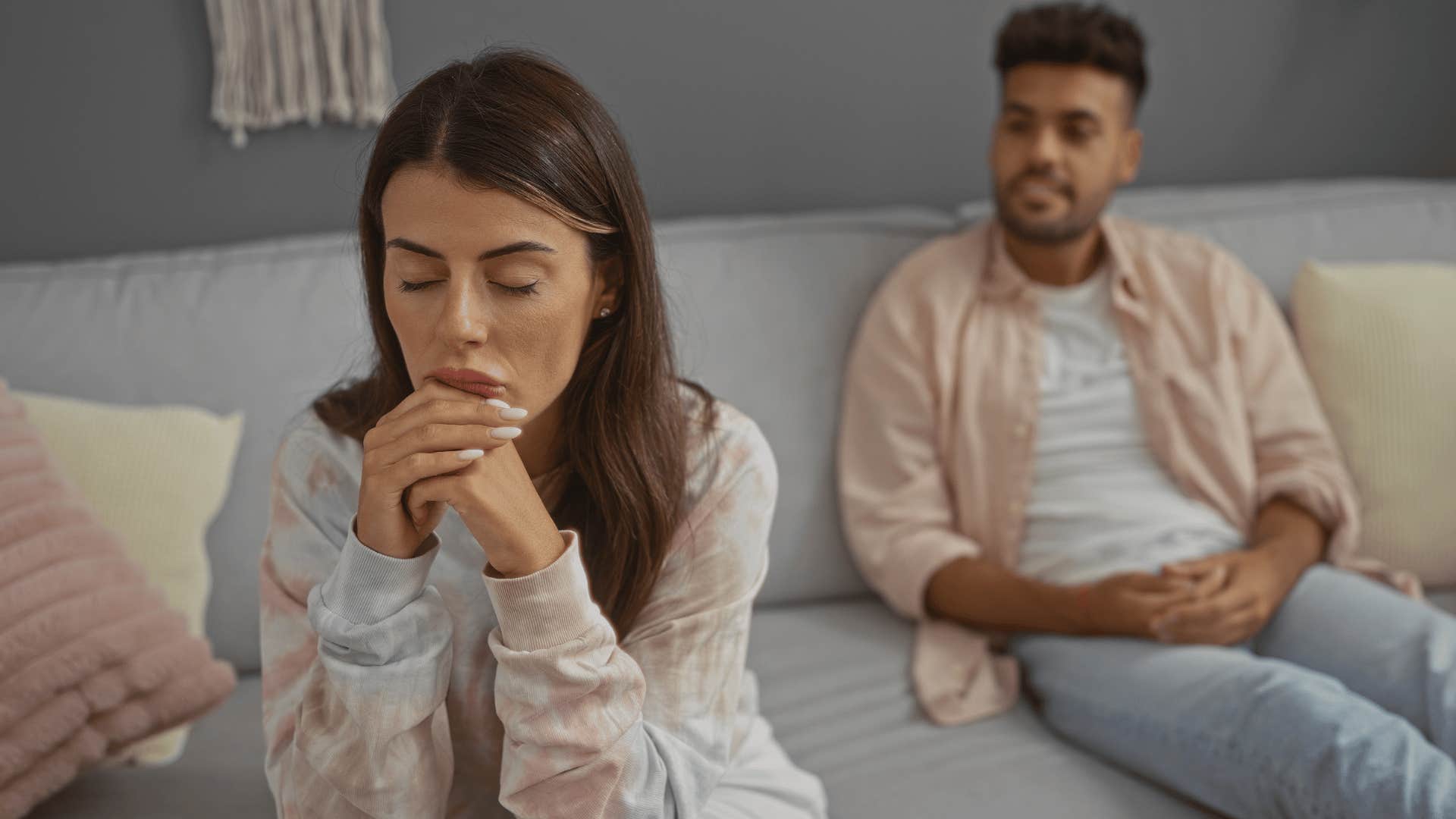 woman looking exhausted as man keeps talking 
