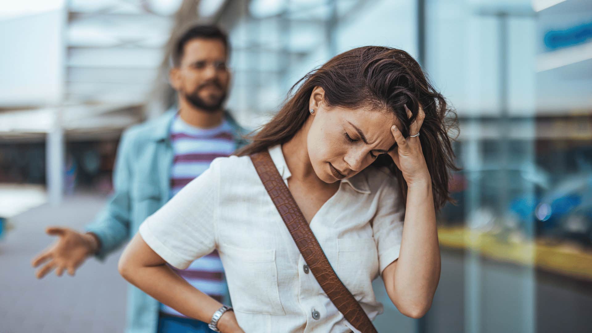 frustrated woman walking away from angry man