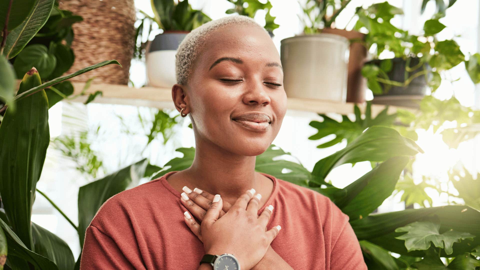 smiling woman meditating holding her heart