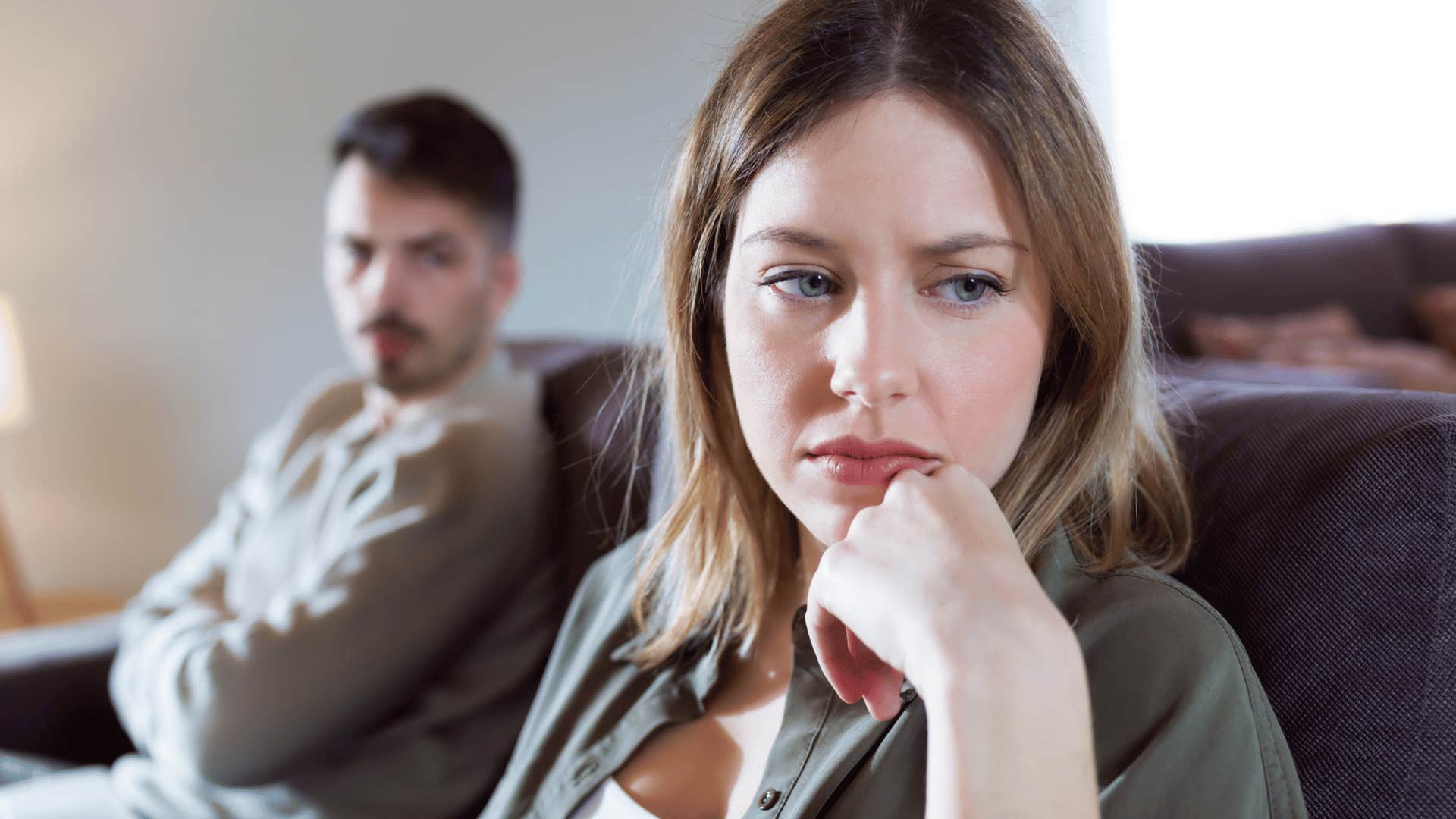 sensitive sad woman turned away from frustrated man