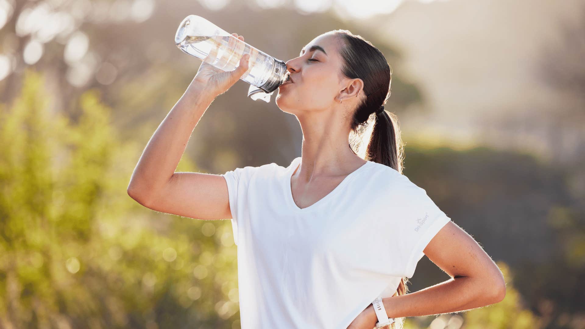 woman drinking water after long run