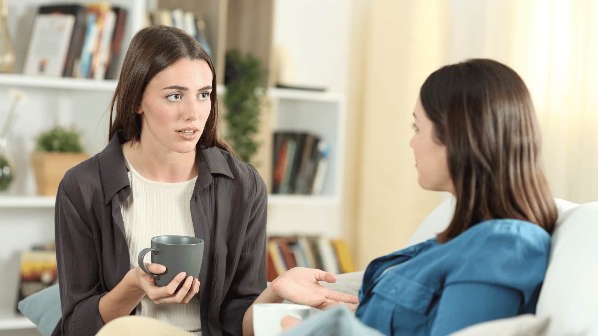annoyed woman confronting friend on couch