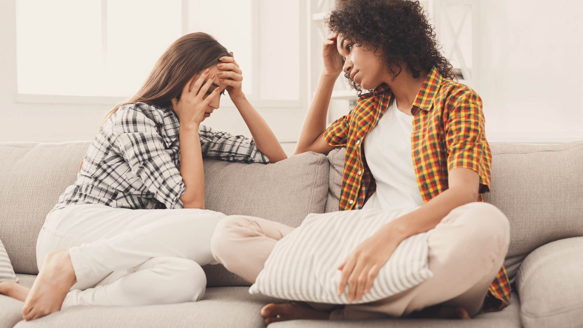 upset friends having conversation on couch