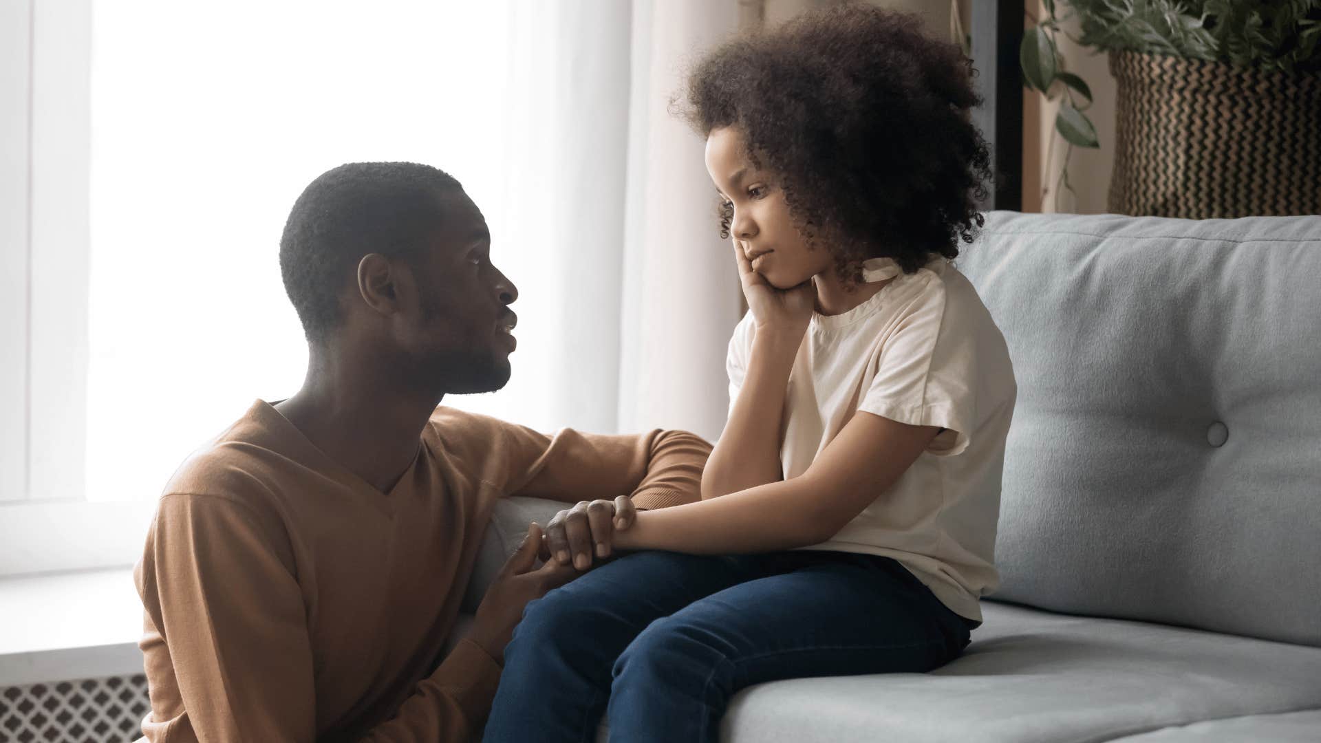 father talking to young daughter