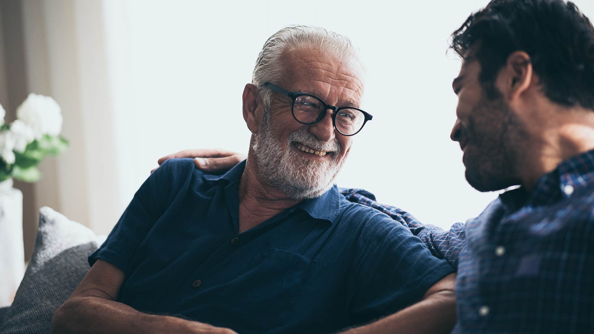 older man smiling and talking to younger man
