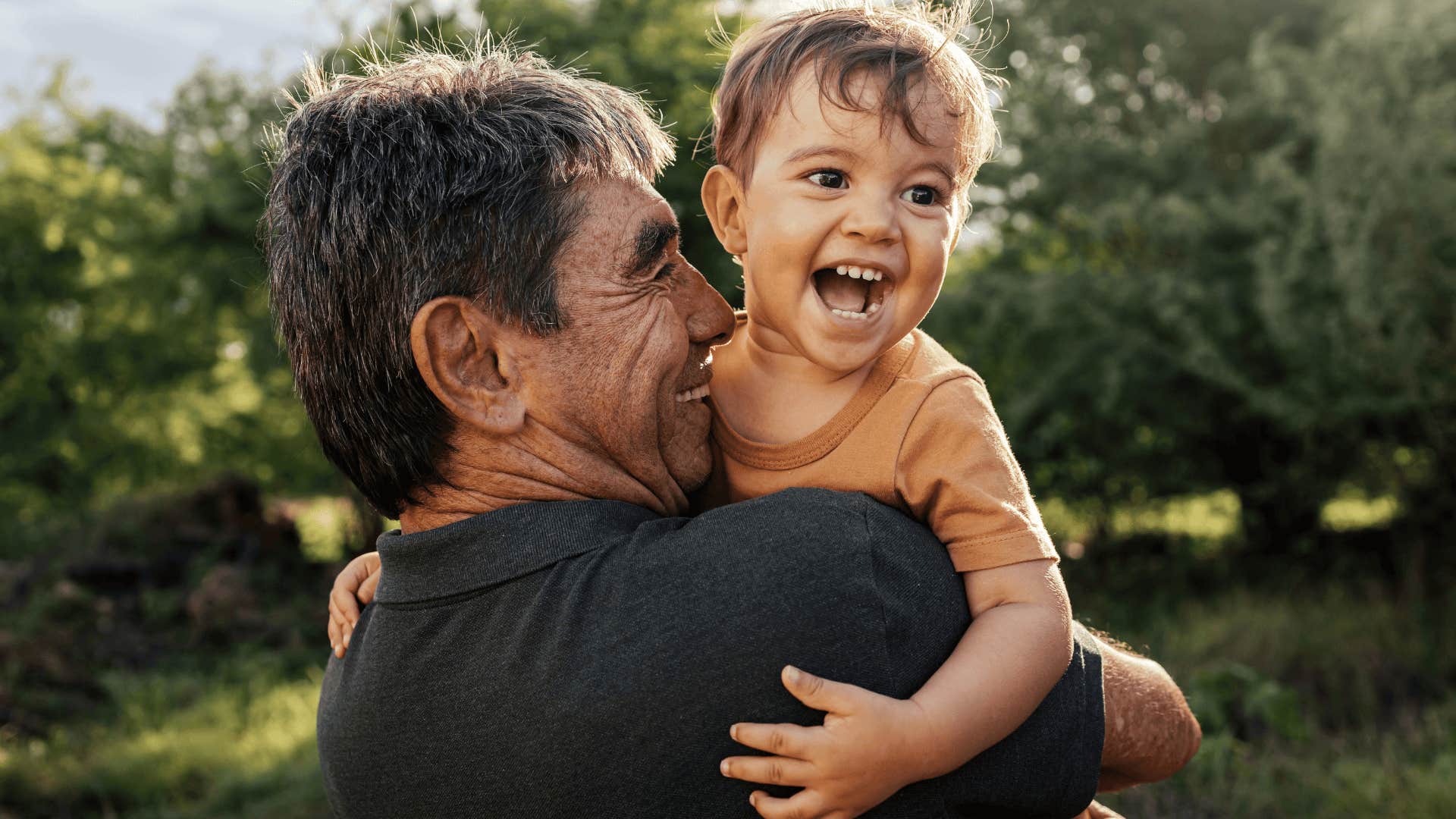 man smiling and holding a young boy