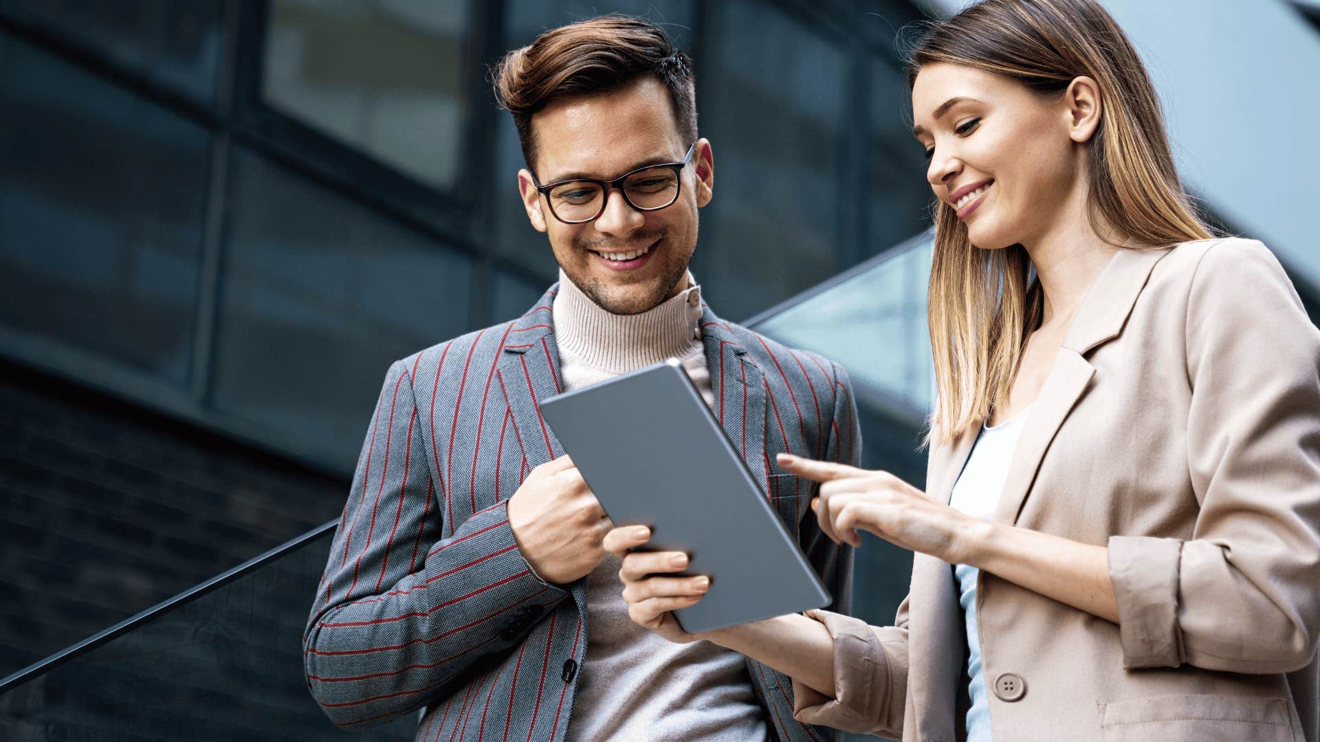 co-workers smiling and looking at a tablet