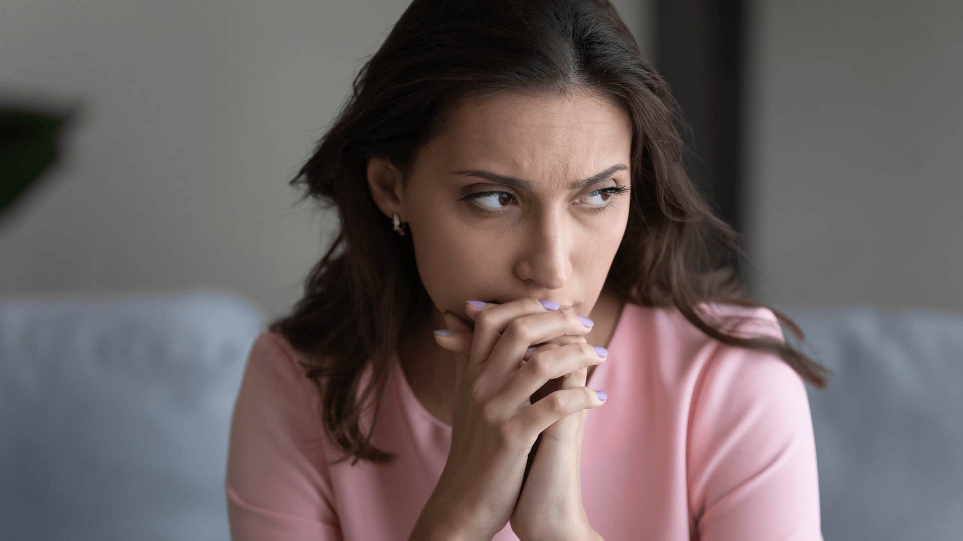 woman thinking with her hands clasped
