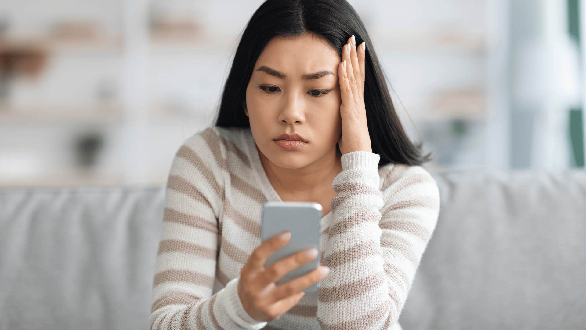 annoyed woman looking at her phone