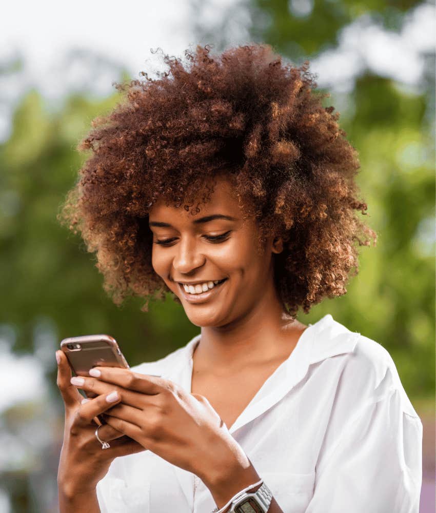 Woman with phone smiles because he posted an amazing thing about her