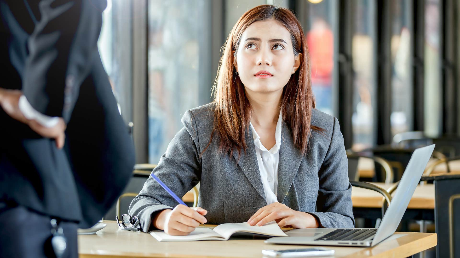 Annoyed Gen Z woman looking at her boss