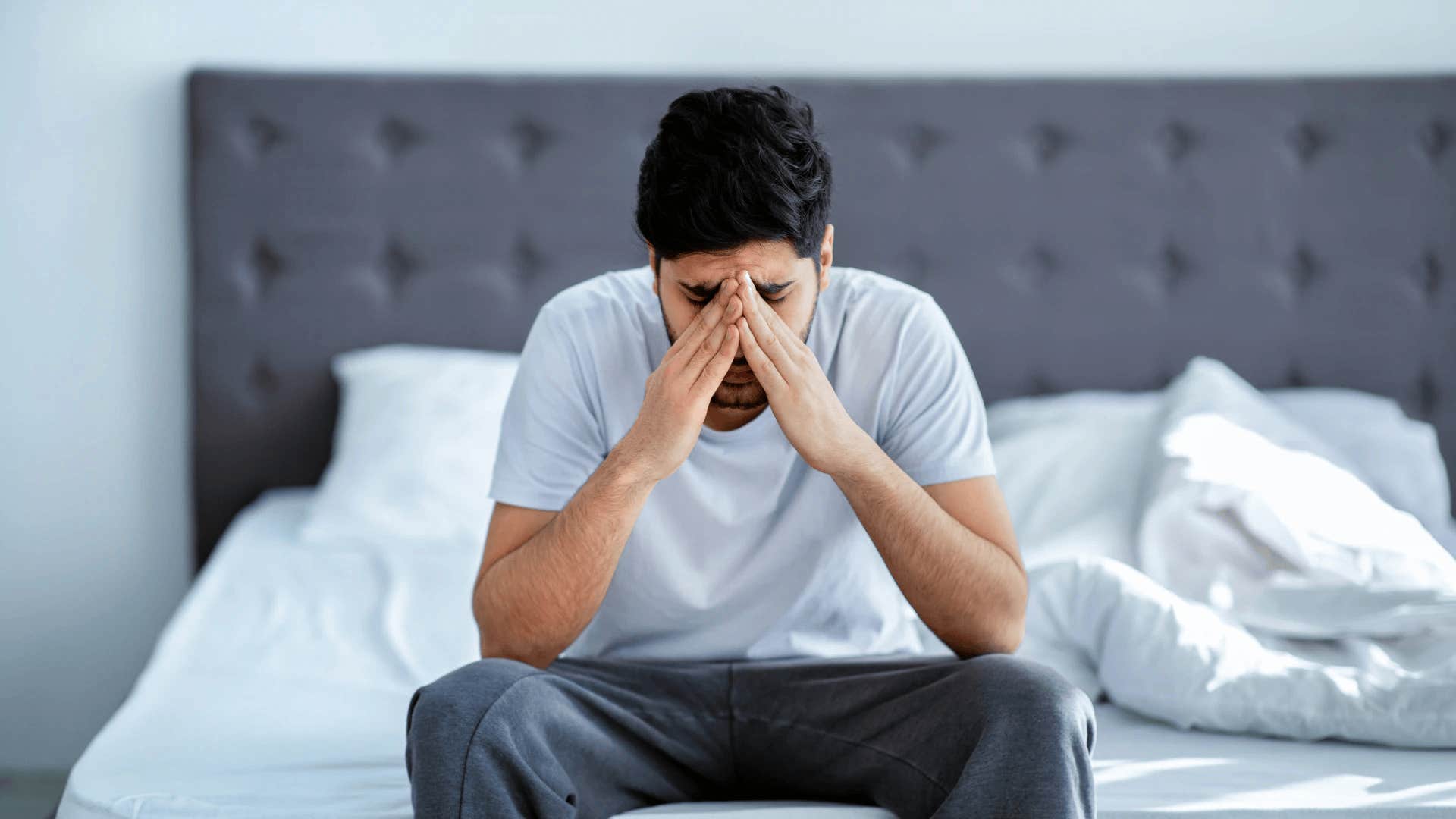 man sitting on bed haunted by regrets that destroyed his marriage