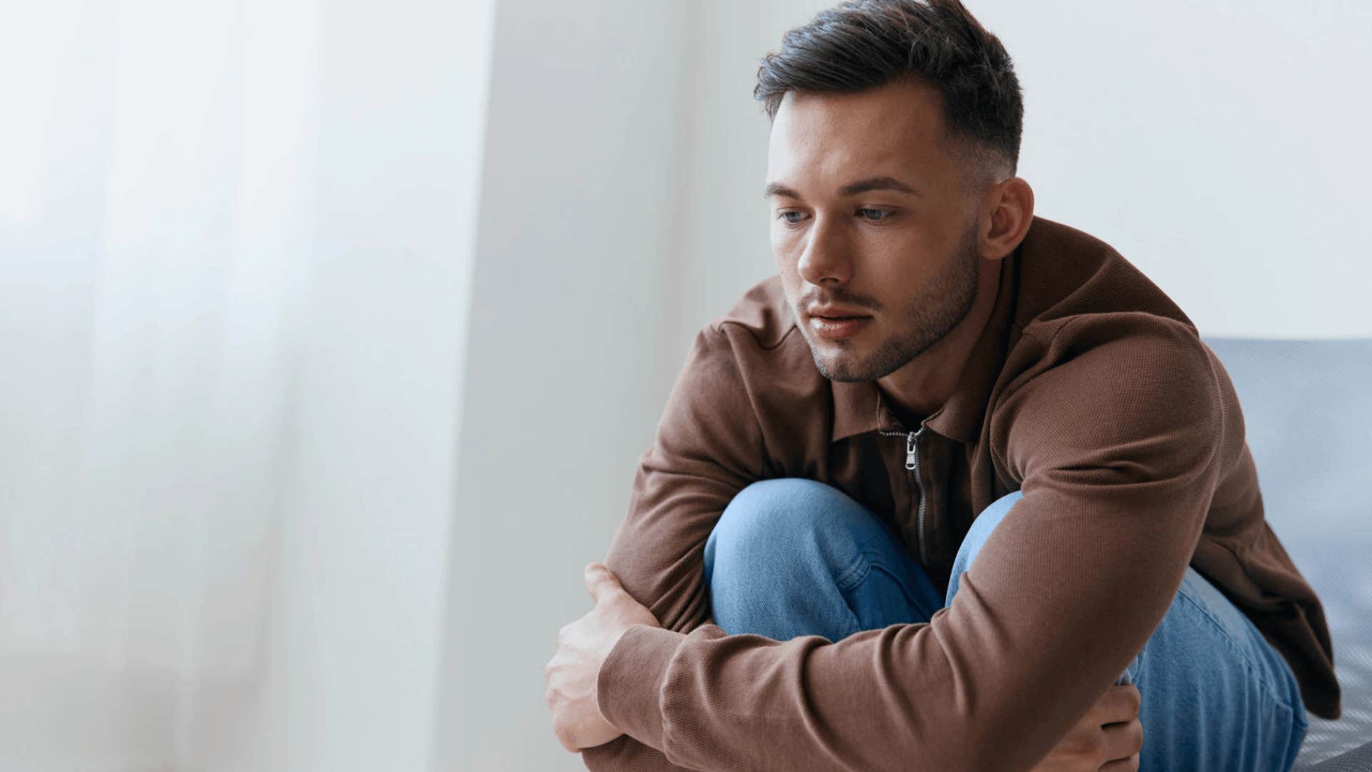 upset man hugging himself haunted by regrets that destroyed his marriage