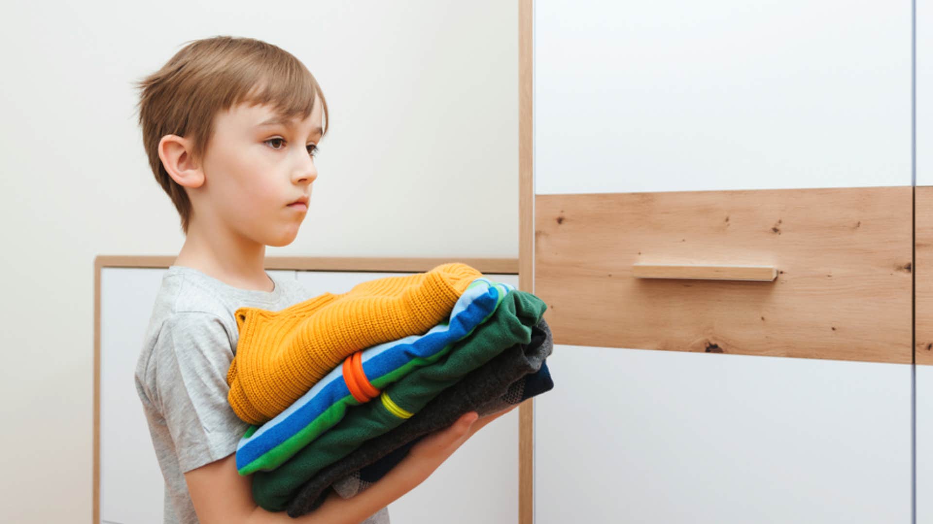 kid moving his clothing to his own room