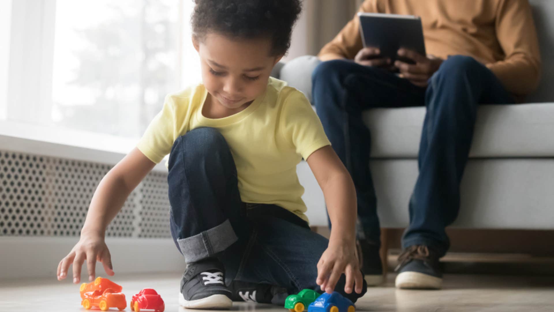 little boy quietly playing with toys