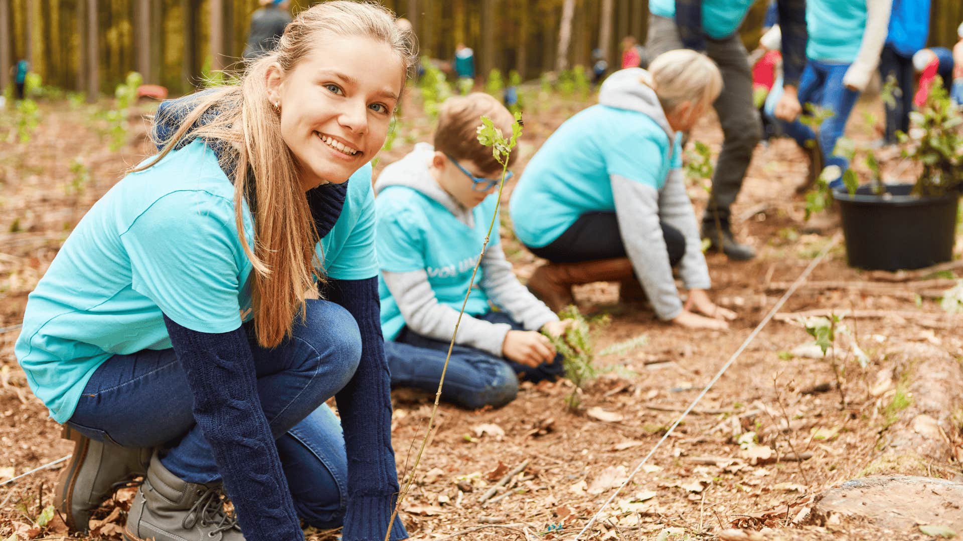 young woman planting seeds with her family
