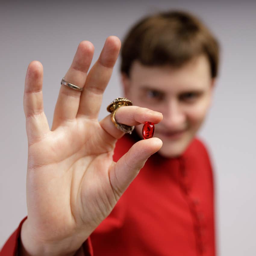 man holding red pill as terrifying reality 